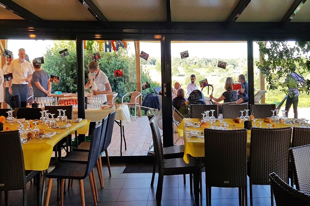 Les baies vitrées de la salle ouvrent sur la terrasse couverte